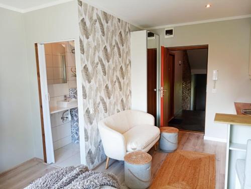 a living room with a white chair and a sink at Urocze Studio 7 z parkingiem in Katowice
