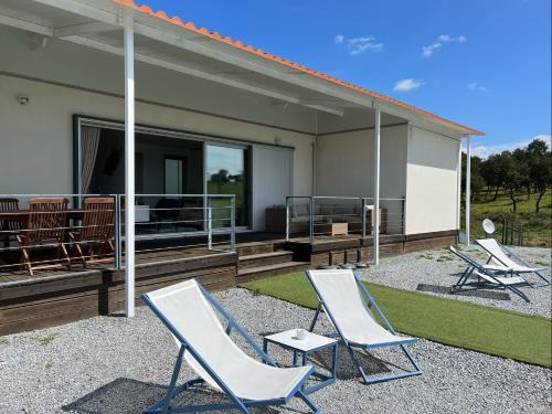 a group of chairs sitting on the patio of a house at Herdade Terra rica in Alcácer do Sal