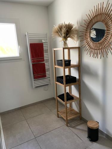 een kamer met een plank met handdoeken en een spiegel bij Chambre avec salle de bain privée dans villa in Manosque