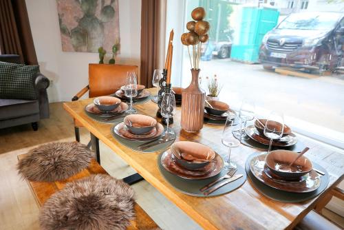 una mesa de madera con platos y vasos. en Zentrale Designoase, en Hamburgo