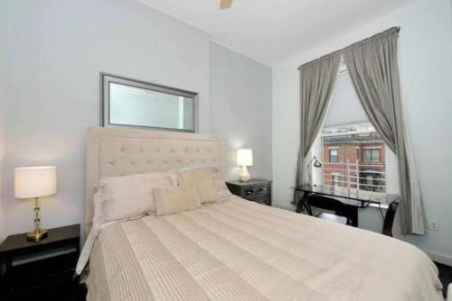 Habitación blanca con cama y ventana en Cozy 1BR Apartment in Upper West Side! en Nueva York