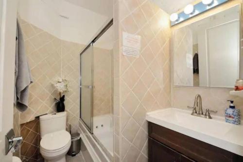 een badkamer met een toilet, een wastafel en een spiegel bij Cozy 1BR Apartment in Upper West Side! in New York