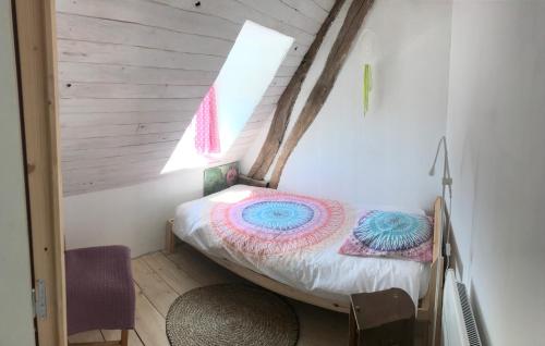 a small bed in a room with a window at Appart dans longère Normande au coeur de la Forêt de Lyons 
