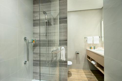 uma casa de banho com um chuveiro, um WC e um lavatório. em Hilton Garden Inn Al Khobar em Al Khobar