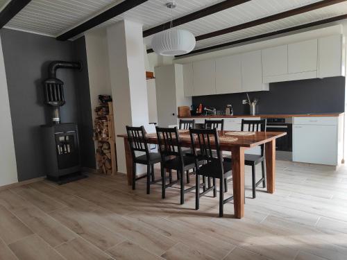eine Küche und ein Esszimmer mit einem Holztisch und Stühlen in der Unterkunft la ferme de la gaby in Le Noirmont