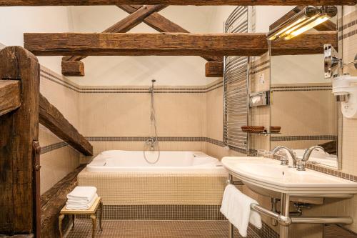 ein Badezimmer mit einer Badewanne und einem Waschbecken in der Unterkunft Iron Gate Hotel & Suites Prague by BHG in Prag