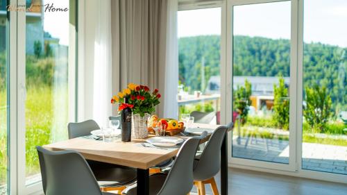 a dining room with a table and chairs and windows at Wonder Home - Domki Hillside tuż przy stoku narciarskim - na terenie kompleksu plac zabaw i zewnętrzna siłownia, sklep, parking in Karpacz