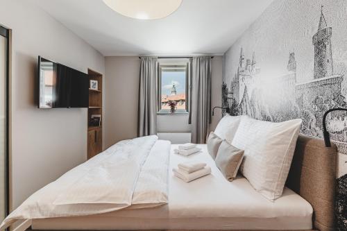 a bedroom with a large bed with white sheets at Penzion KOVÁRNA in Český Krumlov