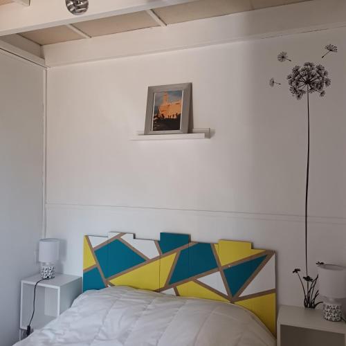 - une chambre avec un lit doté d'une tête de lit colorée dans l'établissement Maison avec piscine commune à 800m de la plage, à Brem-sur-Mer