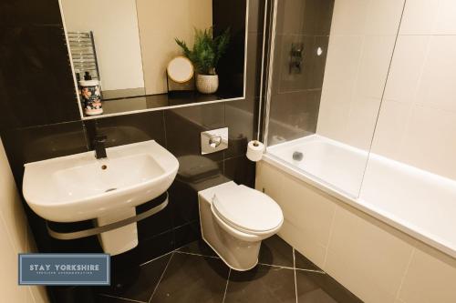 a bathroom with a white toilet and a sink at Stay Yorkshire IQ 4 Blonk Street in Sheffield