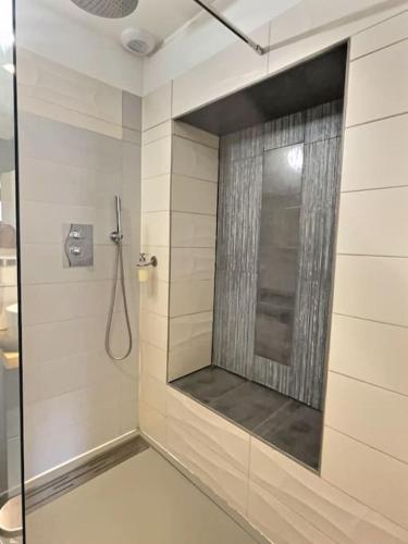 une salle de bain avec une douche avec une porte vitrée dans l'établissement ''Le Graff'' de Miss.K Conciergerie, à Mâcon