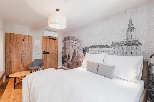 a bedroom with a bed with a drawing on the wall at Penzion KOVÁRNA in Český Krumlov