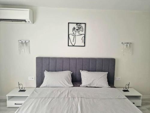 Central Luxe Apartment - Elisha في مدينة فارنا: غرفة نوم بسرير كبير مع مواقف ليلتين