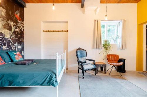 um quarto com uma cama e uma cadeira em The Corner House em Kampen