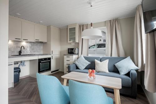 a living room with a blue couch and a table at Tanumstrand SPA & Resort Stugor in Grebbestad