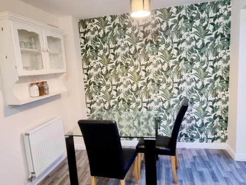 a dining room with a table and chairs and a wallpaper at Stunning 3 bed home at the heart of Wolverhampton in Wolverhampton