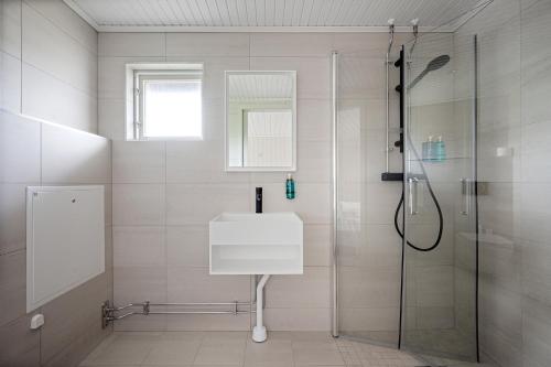 La salle de bains est pourvue d'un lavabo et d'une douche. dans l'établissement Tanumstrand SPA & Resort Stugor, à Grebbestad