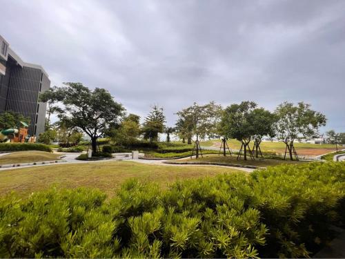 un parco con cespugli e alberi e un edificio di 2 br Laguna, SkyPark, Bang Tao a Thalang