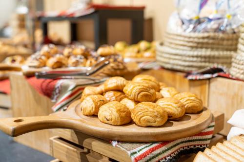 Una mesa con un montón de pasteles en una bandeja. en Hilton Garden Inn Al Khobar, en Al Khobar