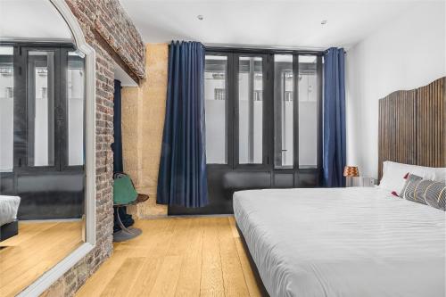 - une chambre avec un lit et quelques fenêtres dans l'établissement Paridily Circus, à Paris