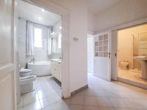 y baño con aseo, bañera y lavamanos. en Villa Borghese Large Apartment en Roma