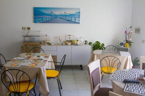 una cocina con 2 mesas y sillas y una cocina con aorus en B&B Sole Luna, en Marina di Gioiosa Ionica