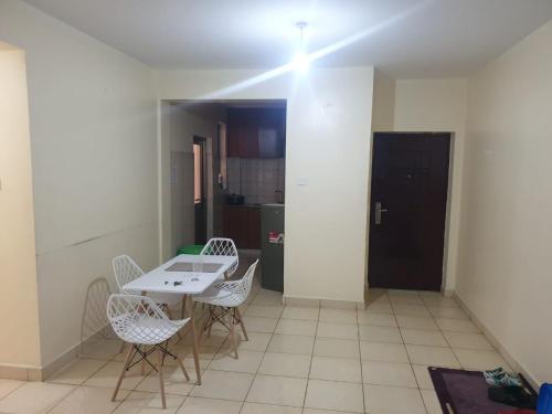 a room with a table and chairs and a kitchen at Spacious 3bedroom in Greatwall Gardens in Athi River