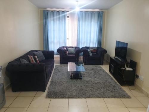 a living room with two couches and a coffee table at Spacious 3bedroom in Greatwall Gardens in Athi River