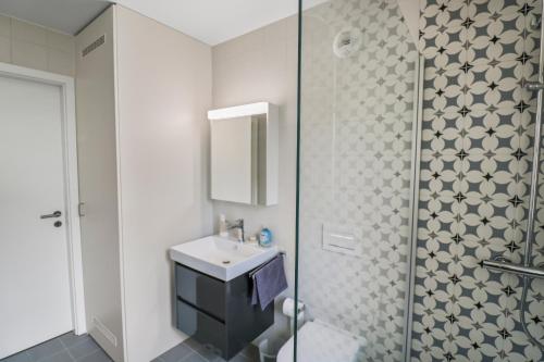 a bathroom with a sink and a shower at Appartement élégant avec terrasse privée in Villars-sur-Glâne