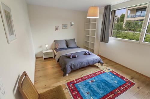 a small bedroom with a bed and a window at Appartement élégant avec terrasse privée in Villars-sur-Glâne