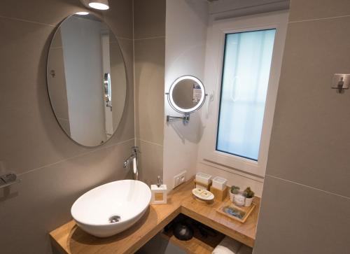 ein Badezimmer mit einem weißen Waschbecken und einem Spiegel in der Unterkunft Monte 21 - San Giusto in Triest