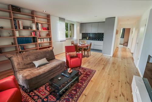 a living room with a couch and a table at Appartement élégant avec terrasse privée in Villars-sur-Glâne