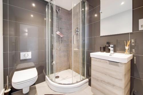 a bathroom with a shower and a toilet and a sink at Luxury New 2 Bed/2 Bathroom Flat With Balcony in Edgware