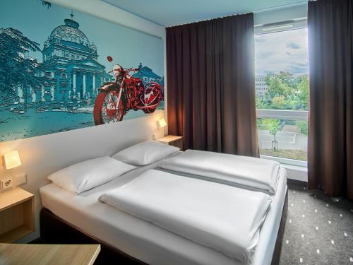 ein Schlafzimmer mit einem Bett mit einem Motorrad an der Wand in der Unterkunft B&B Hotel Bad Homburg in Bad Homburg vor der Höhe