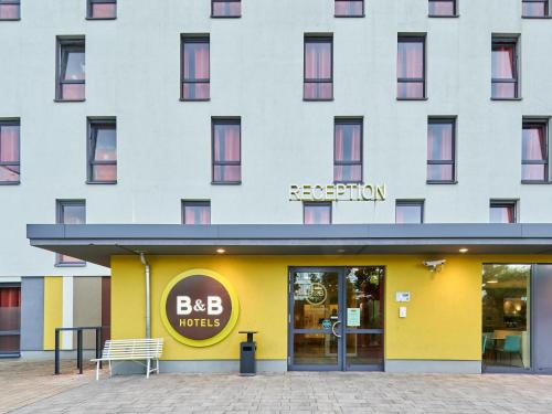 a building with a yellow and white facade at B&B Hotel Bad Homburg in Bad Homburg vor der Höhe