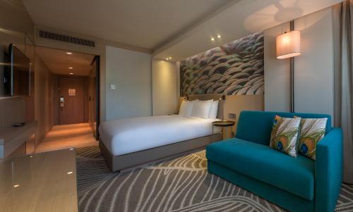 a hotel room with a bed and a blue chair at DoubleTree by Hilton Istanbul - Sirkeci in Istanbul