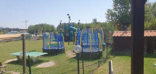 a park with a playground with a slide at Luxe Mobilehome with dishwasher and airconditioning included fits 4 adults and 1 child, Ameglia, Ligurie, Cinqueterre, North Italy, Beach, Pool, Glamping in Ameglia