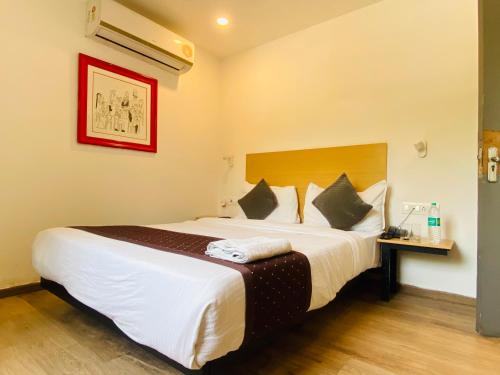 a bedroom with a large bed in a room at Qotel Comfort IP Residency East Delhi Preet Vihar in New Delhi