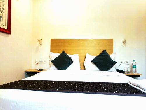 a bedroom with a large bed with black and white pillows at Qotel Comfort IP Residency East Delhi Preet Vihar in New Delhi