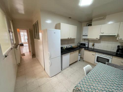 une cuisine avec un réfrigérateur blanc et une table dans l'établissement Trouville Superbe appartement hyper centre, à Trouville-sur-Mer