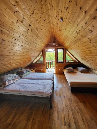 - 2 lits dans une chambre dotée d'un plafond en bois dans l'établissement Beržoro pakrantė, à Berżory