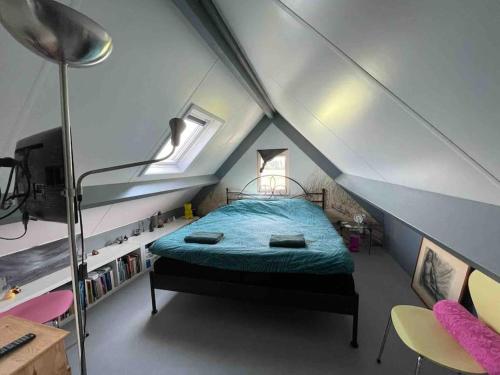 a bedroom with a bed in a attic at Mooie schuur appartement in Den Horn in Den Horn