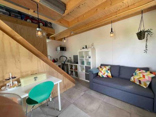 a living room with a blue couch and a table at Mooie schuur appartement in Den Horn in Den Horn
