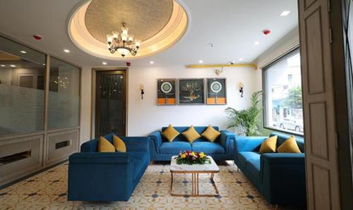 a living room with a blue couch and yellow pillows at FabHotel Prime Hampton By IC's in Noida