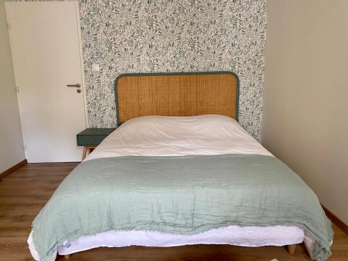 - un lit avec une tête de lit en bois dans une chambre dans l'établissement La chambre de Madeleine, à Commercy