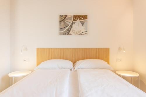 a white bed with two white pillows on it at R&B al lago in Domaso