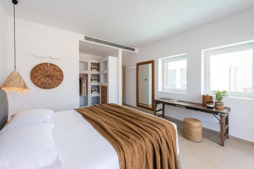 Exclusive Luxury Moca beachfront villa, Molos, Paros في Molos Parou: غرفة نوم بيضاء مع سرير ومكتب