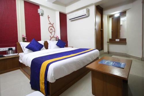 um quarto com uma cama grande, uma secretária e um sidx sidx em HOTEL CAMPUS em Ahmedabad