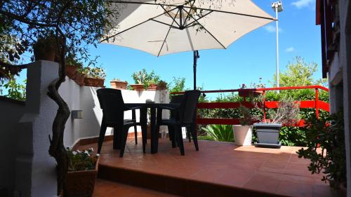 un tavolo e sedie su un patio con ombrellone di home sweet home sea a Mondello