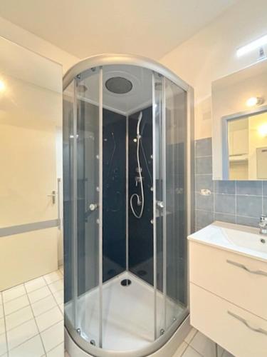 une douche avec une porte vitrée dans une salle de bain dans l'établissement Appartement T2 situé proche de la mer terrasse parking privé 4POPL8, au Barcarès